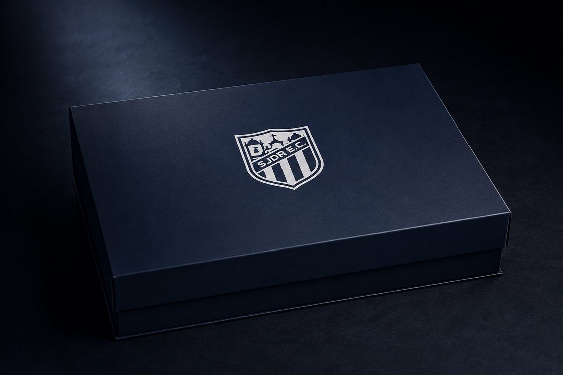 Caixa personalizada do kit do sócio, em azul-marinho com o escudo do SJDR